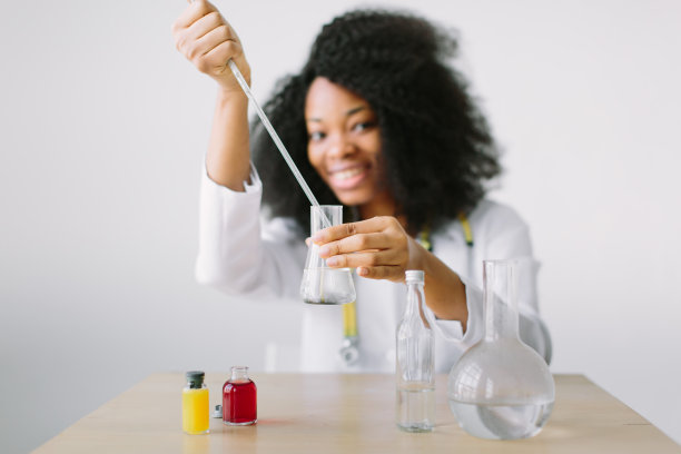 年轻美丽的非裔美国女孩在实验室里拿着玻璃设备图片下载