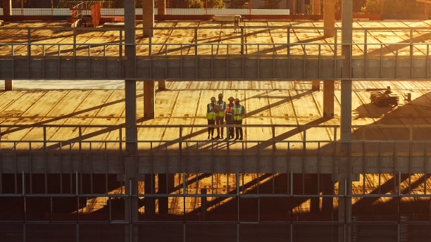 鸟瞰图:多样化的专家团队检查商业，工业建筑/摩天大楼模板施工现场。房地产项目由土木工程师，投资者，建筑师和工人领导图片下载