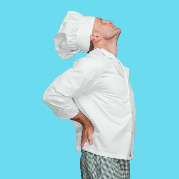 白人男厨师穿着夹克站在蓝色背景前图片下载