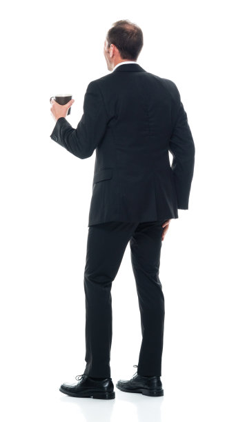 白人年轻男子站在白色背景下穿着商务服装，拿着咖啡杯图片下载