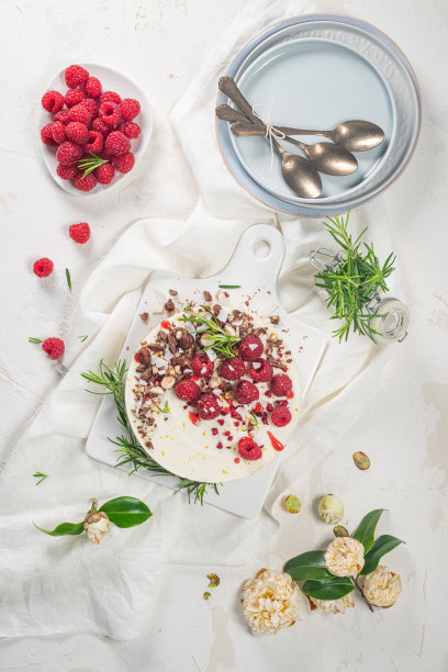 厨房台面上放着覆盆子、巧克力、榛子和迷迭香叶的芝士蛋糕图片下载