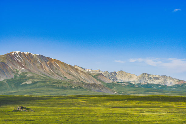 岩石山脊在地平线上的山谷，绿色的斜坡平缓的小山，美丽的自然放松和冥想素材图片