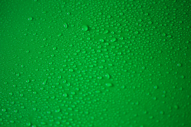 水滴落在绿色的表面上图片下载