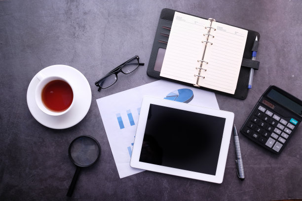 俯视图的数字平板电脑屏幕和财务数据在办公桌上图片下载