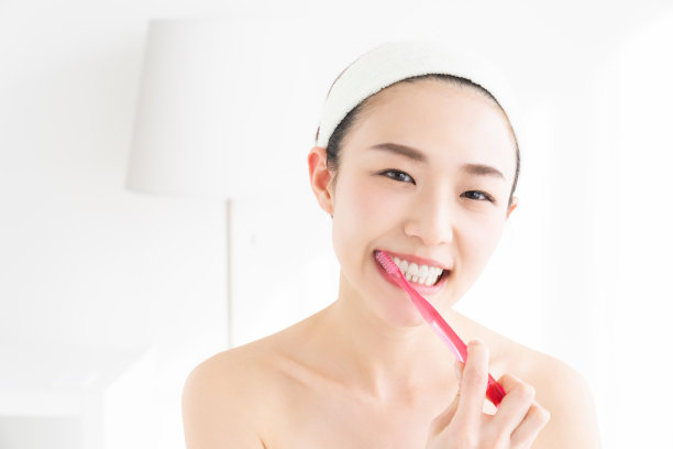 亚洲女性用健康的牙齿拿着牙刷，进行口腔护理图片下载