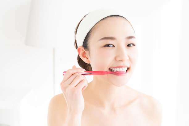 亚洲女性用健康的牙齿拿着牙刷，进行口腔护理图片下载