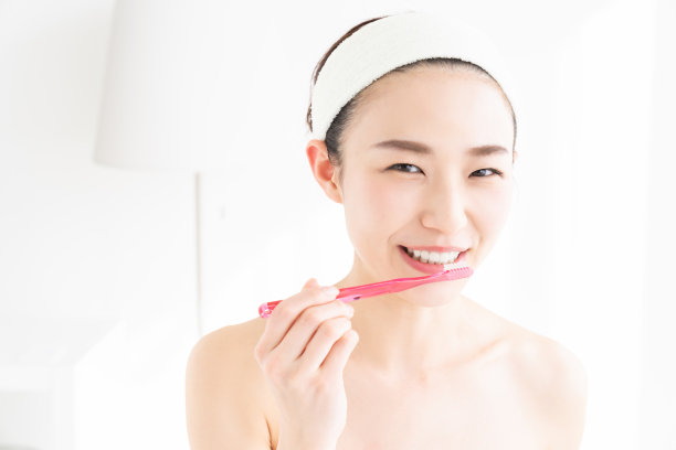 亚洲女性用健康的牙齿拿着牙刷，进行口腔护理图片下载