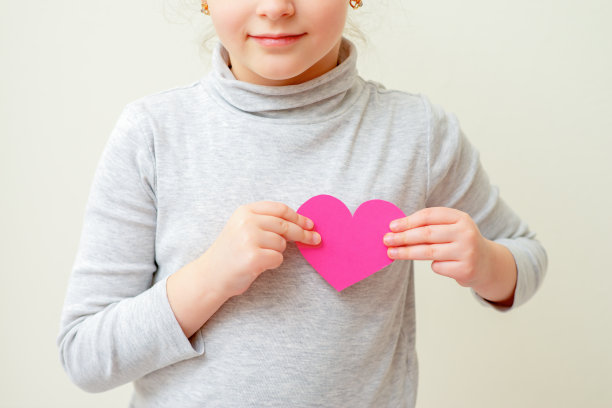 小女孩拿着粉红色的心。图片下载