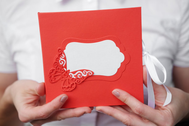 女孩手里拿着一个红色的名牌信封。图片下载