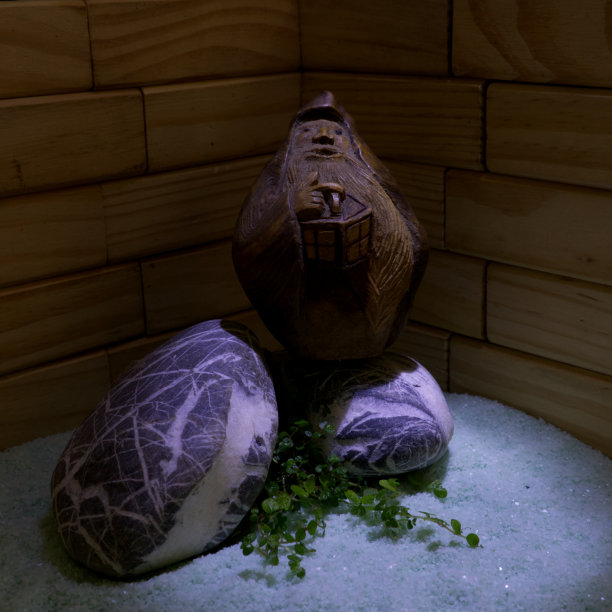 雕刻的木制雕像的侏儒与灯笼休息在花岗岩石头图片下载