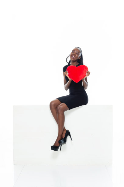 非洲裔女性在白色背景下穿着裙子和拿着盒子图片下载