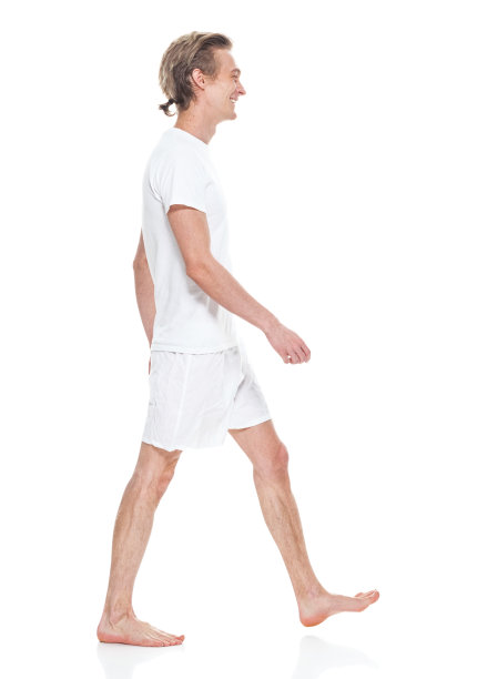 白人年轻男性穿着内衣走在白色背景前图片下载