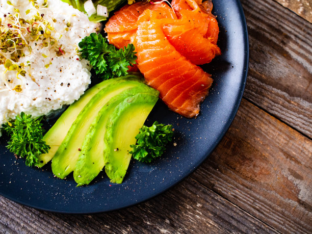 欧式早餐——木桌上放着白软干酪、面包、鳄梨色拉酱和蔬菜图片下载