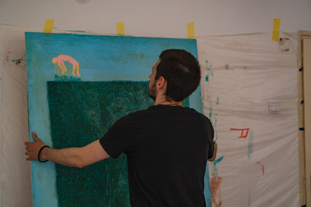 年轻的艺术家把他的作品挂在墙上图片下载