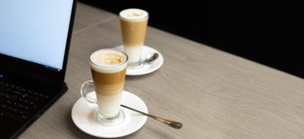 双人商务早餐，咖啡拿铁，笔记本电脑，带复印空间的木桌图片下载
