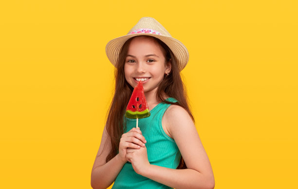 拿着西瓜棒棒糖的快乐少女图片下载