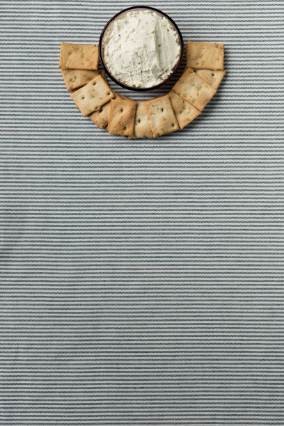 一块条纹桌布上放着一盘饼干和凝乳。图片下载