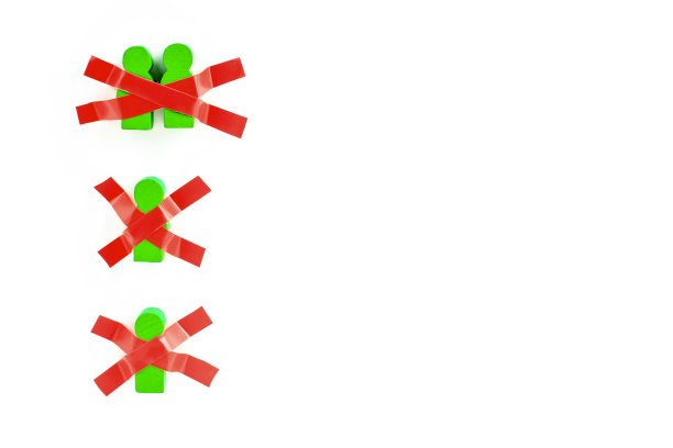 玩具木制的人用胶带粘在白色的墙上。在新冠肺炎大流行期间保持身体隔离、在家、社交距离、隔离、强制隔离、禁闭的概念。图片下载