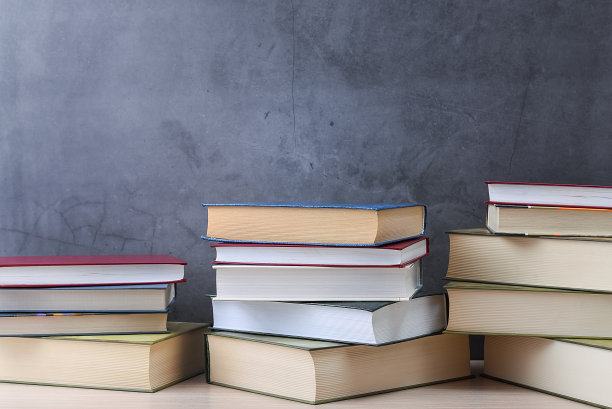 几摞书，灰色背景的特写。回到学校，接受教育，学习，图片下载