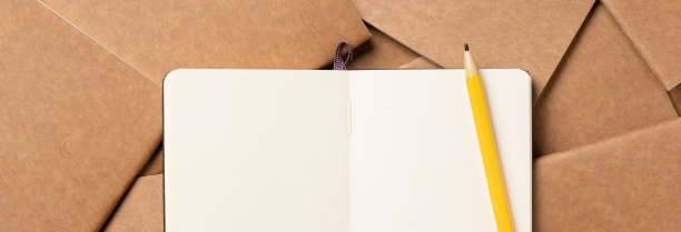 打开笔记本，用铅笔在棕色的牛皮纸笔记本无序对齐在桌子的背景上。展示内容或设计的模型模板。内容营销的概念图片下载