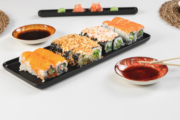 一套寿司和卷三文鱼和金枪鱼，鳄梨，加州，maki，酱油，筷子特写。图片下载
