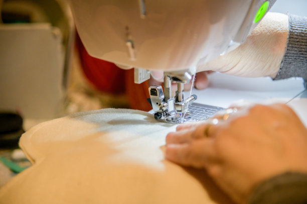 家庭爱好和工匠在家。手与缝纫机的特写图片下载