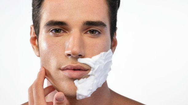 一名英俊的男子准备刮掉胡须，以拥有光滑的皮肤和干净的脸。图片下载