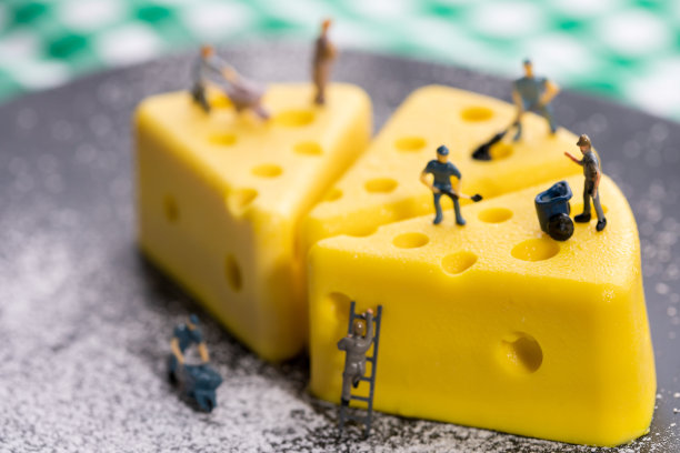 一个小工人正在做一个奶酪蛋糕。模型工人，小型公司员工，雇主形象。图片下载