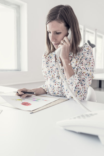 严肃的女商人在分析重要数据时打电话图片下载
