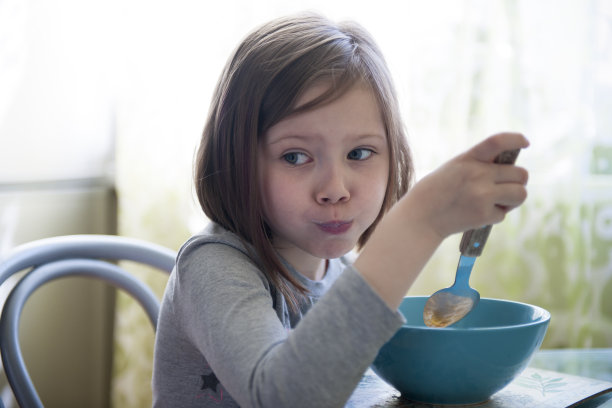 一张五岁小女孩吃饭的照片。图片下载
