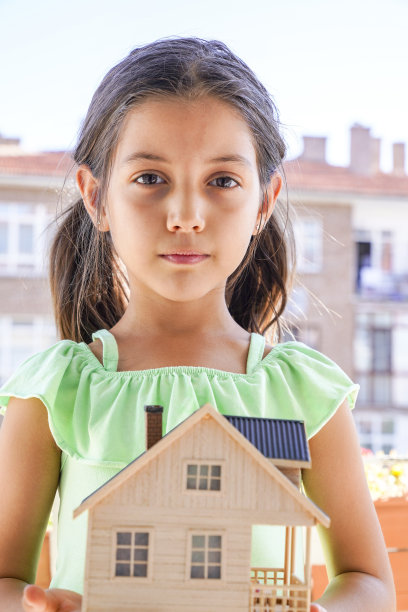 小女孩拿着木屋模型。管理，抵押，家庭和金融概念。——图片图片下载