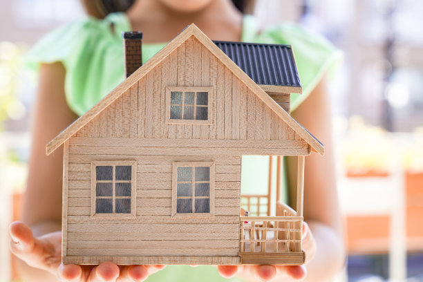 小女孩拿着木屋模型。管理，抵押，家庭和金融概念。——图片图片下载