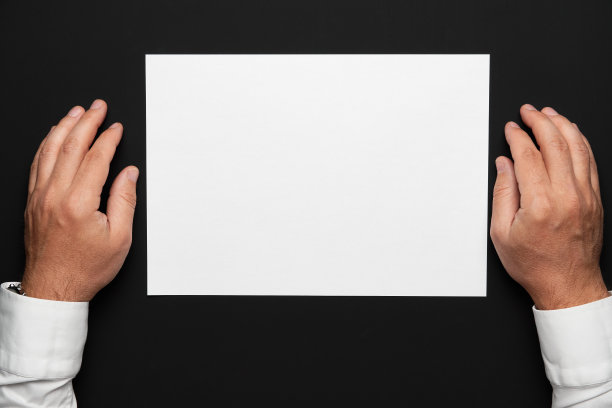 一张白纸，一个商人的手放在一张黑桌子上，一件白衬衫和一块手表，一张俯视图——任何文本或题词的模板图片下载