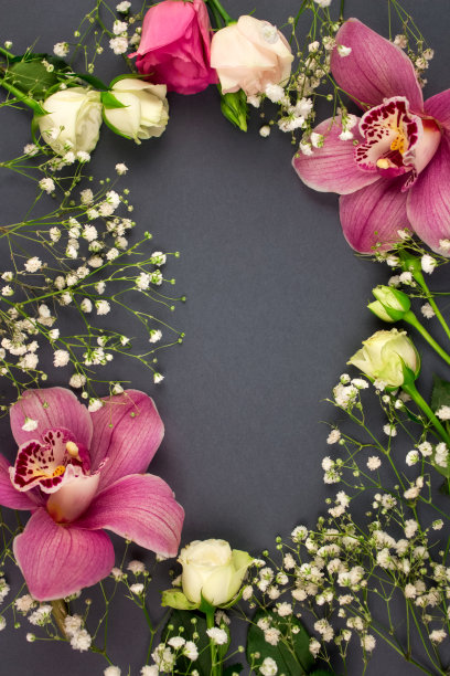 花垂直平铺构成。美丽的兰花，玫瑰和gypsophila在深灰色背景与复制空间，选择性聚焦。婚礼或假日概念图片下载