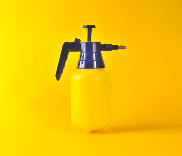 喷瓶在黄色背景上。便携式压力喷水泵。喷雾瓶。图片下载