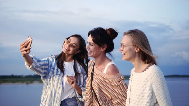 三个女模特在自拍，然后在看照片图片下载