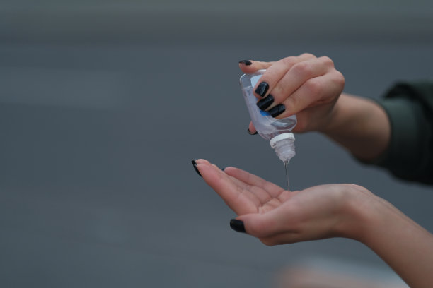 女孩在大街上使用消毒剂。图片下载