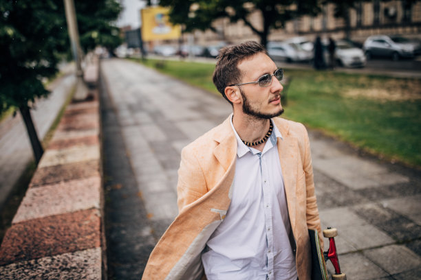 带着滑板去上班的现代年轻商人图片下载