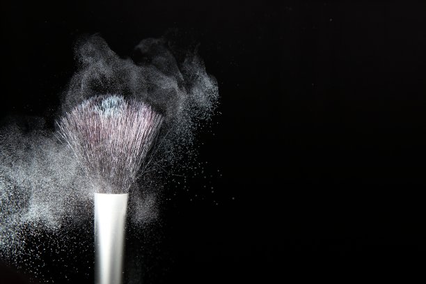 化妆刷和粉末在黑色的背景图片下载