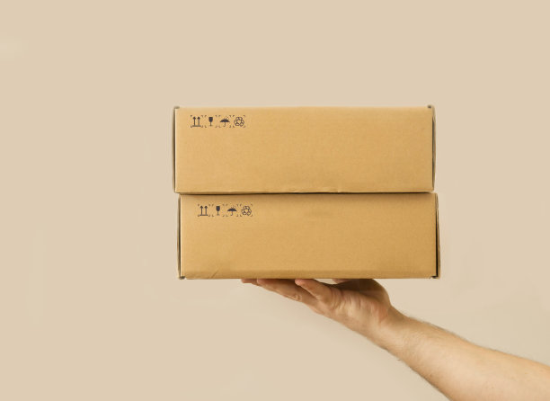 男人的手有两个箱子。灰色的背景。交付的概念。图片下载