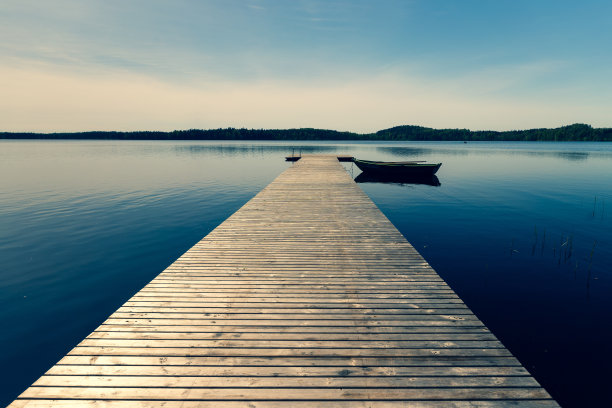 春天，一艘木船停泊在湖边的码头上图片下载