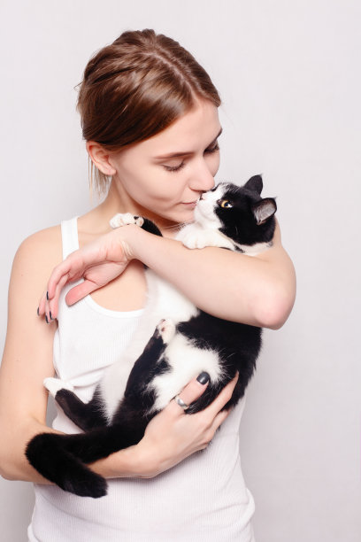 美丽微笑的女人，在她的怀里抱着一只小猫，工作室照片，特写图片下载