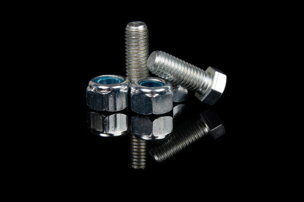 黑色背景上的钢螺栓和螺母图片下载