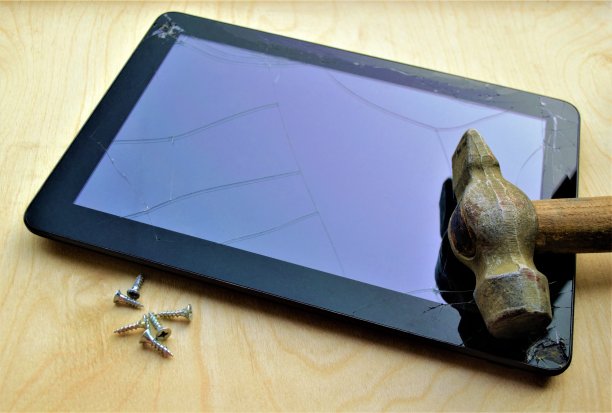 老校“修”碑:近景老锤和小螺丝在碑破碎的屏幕上，发散的玻璃有裂缝，边角破碎。光胶合板背景图片下载