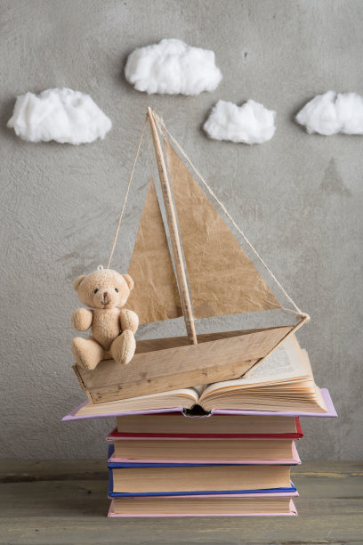 教育是一种旅行的概念，玩具船和书像海浪一样放在木桌上，启发着一个写童话的人图片下载