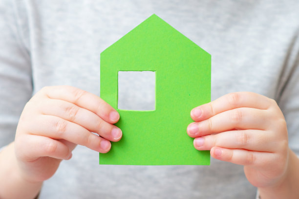 孩子手里拿着小纸房子。图片下载