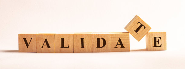 VALIDATE这个词是由木质立方体组成的，这些立方体矗立在一个明亮的背景上图片下载