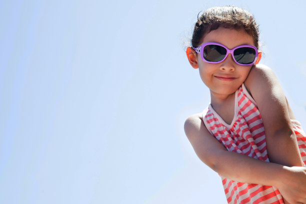 美丽的小女孩在面对镜头的时候戴着太阳镜享受夏天图片下载