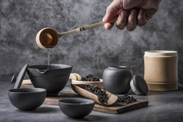 室内以中国茶道著名照片为背景的陶瓷茶壶和茶杯。图片下载