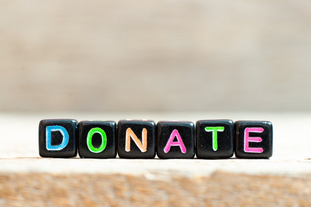 黑色珠与彩色字捐赠在木材背景上图片下载